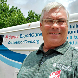 Mark Slicker standing next to the Carter BloodCare bus